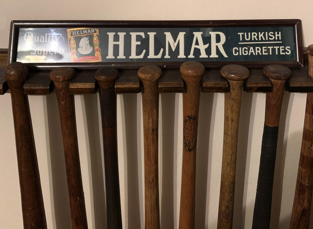Display of baseball bats with vintage tobacco sign
