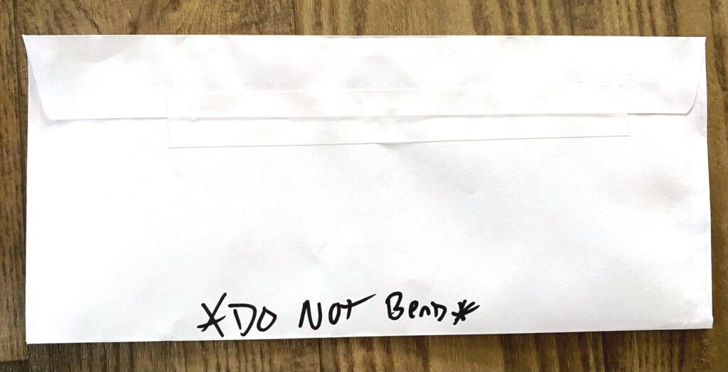 Envelope with the phrase "Do not bend" written on the bottom edge